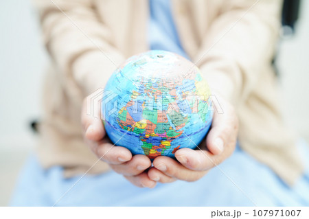 Bangkok, Thailand April 1, 2023 Asian elderly woman patient holding globe in hand at hospital. 107971007