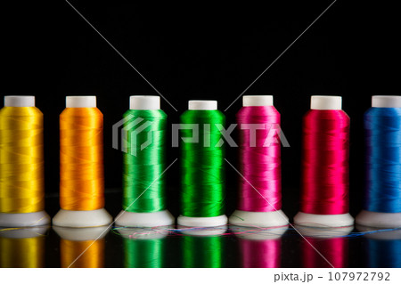 set of different color sewing threads,on black background. set of different color sewing threads,on black background. 107972792