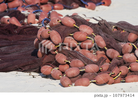 red fishing net on sandy closeup 107973414