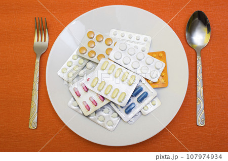 Pills and capsules with fork - food, protection quarantine, coronavirus, covid19 Pills and capsules with fork - food, protection quarantine, coronavirus, covid19 107974934