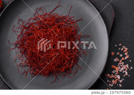 Red thin hot chili threads on a dark background Red thin hot chili threads on a dark background 107975060