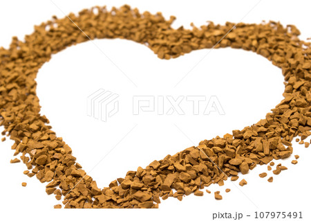 Dry instant coffee granules in the shape of a heart - brown texture Dry instant coffee granules in the shape of a heart - brown texture 107975491