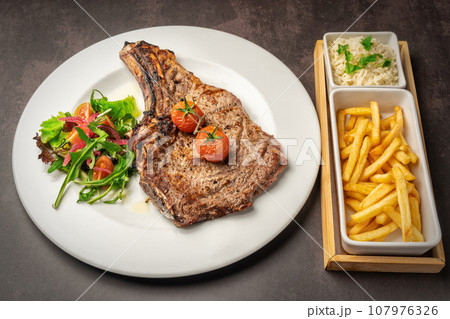 Delicious grilled lamb chops with fried potatoes on a marble background, food photography, rice, potato in the background Delicious grilled lamb chops with fried potatoes on a marble background, food photography, rice, potato in the background 107976326