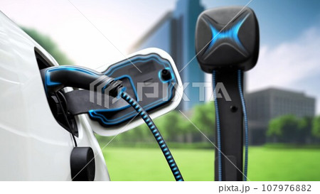 Electric car plugged in with charging station to recharge battery. Peruse 107976882