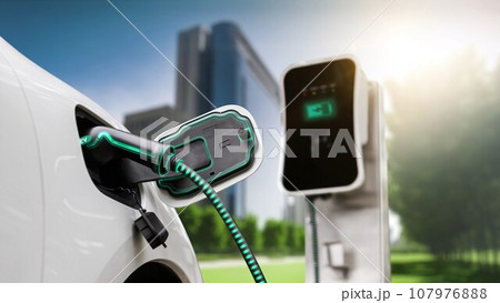 Electric car plugged in with charging station to recharge battery. Peruse 107976888