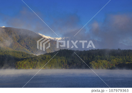 青木湖の湖面から沸き上がる朝もやと三段紅葉　長野県大町市 107979363