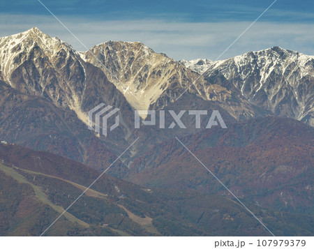 白沢峠からみる冠雪した白馬三山との三段紅葉　長野県白馬村（ドローンによる空撮） 107979379