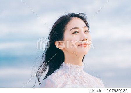 青空背景の若い女性のビューティーイメージ 107980122