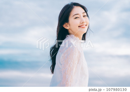 青空背景の若い女性のビューティーイメージ 107980130