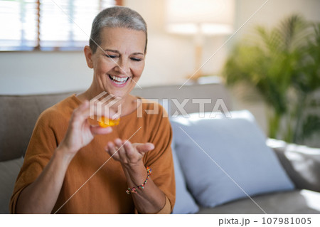 Close up Caucasian senior holding pill in hand with water feeling sick. from headache, painkiller, healthcare, medicine, treatment, therapy, patient, disease illness concept 107981005