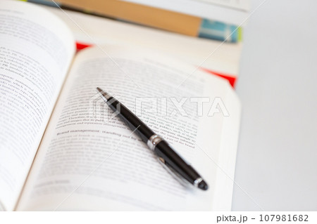 机の上に開いた英語の書籍とペン 研究 学習のイメージ 机の上に開いた英語の書籍とペン 研究 学習のイメージ 107981682