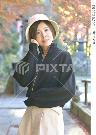秋の神社の境内でポーズをとる若い女性 秋の神社の境内でポーズをとる若い女性 107981963