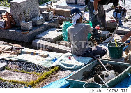 霊園内でお墓の墓所内整備工事を行う職人 107984531
