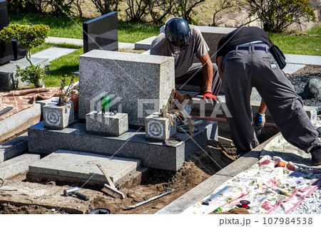 霊園内でお墓の墓所内整備工事を行う職人 霊園内でお墓の墓所内整備工事を行う職人 107984538