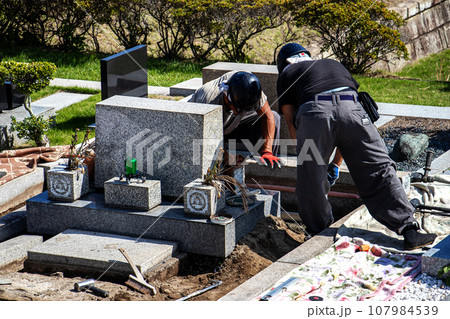 霊園内でお墓の墓所内整備工事を行う職人 霊園内でお墓の墓所内整備工事を行う職人 107984539