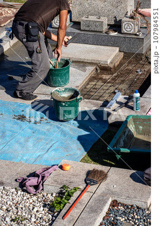 霊園内でお墓の墓所内整備工事を行う職人 霊園内でお墓の墓所内整備工事を行う職人 107984551