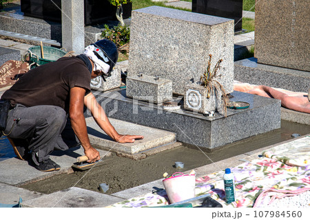 霊園内でお墓の墓所内整備工事を行う職人 霊園内でお墓の墓所内整備工事を行う職人 107984560