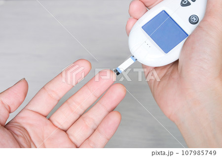 hand of people check diabetes and high blood glucose monitor with digital pressure gauge. Healthcare and Medical concept hand of people check diabetes and high blood glucose monitor with digital pressure gauge. Healthcare and Medical concept 107985749