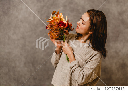 花束を持って愛でる若い女性 花束を持って愛でる若い女性 107987612