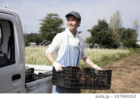 軽トラックとサツマイモを持つ農家の男性 107990263