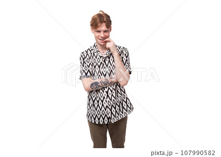 young red-haired man in a rhombus print summer shirt is brainstorming 107990582