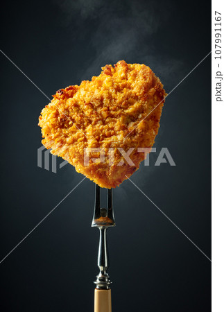 Hot fried schnitzel on a fork. 107991167