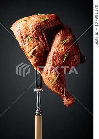 Smoked chicken on a fork sprinkled with rosemary. 107991170