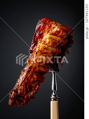 Grilled pork ribs on a fork. Grilled pork ribs on a fork. 107991193