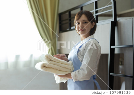 ベッドメイクをする可愛い女性 107991539