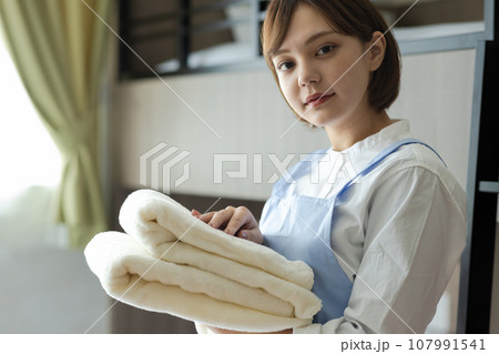 ベッドメイクをする可愛い女性 ベッドメイクをする可愛い女性 107991541