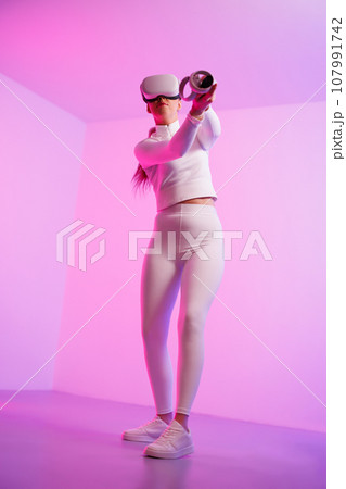 Woman wearing VR glasses practicing golf Woman wearing VR glasses practicing golf 107991742