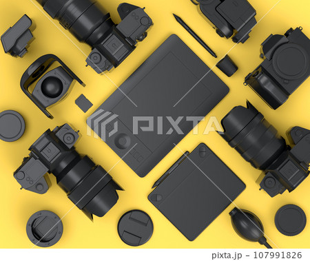 Top view of monochrome designer workspace and photography gear on yellow 107991826