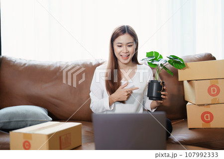 Starting small business entrepreneur of independent young Asian woman online seller using a computer showing products to a customer before making a purchase decision. SME delivery concept. Starting small business entrepreneur of independent young Asian woman online seller using a computer showing products to a customer before making a purchase decision. SME delivery concept. 107992333