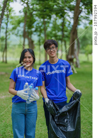 Multiethnic volunteers donate their time holding black garbage bags to collect plastic waste for recycling to reduce pollution in a public park Multiethnic volunteers donate their time holding black garbage bags to collect plastic waste for recycling to reduce pollution in a public park 107992594