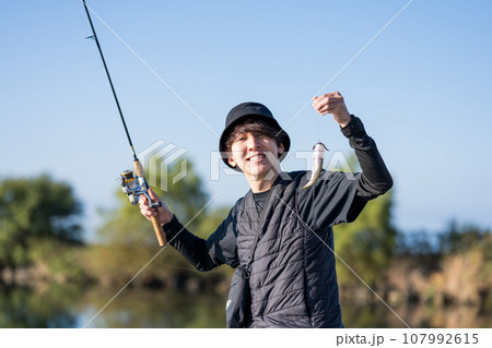 晴れた日の早朝に釣りを楽しむ若い男性 107992615