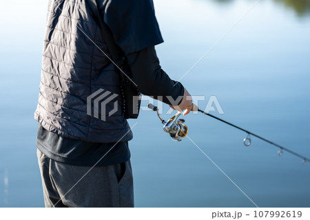晴れた日の早朝に釣りを楽しむ若い男性 107992619