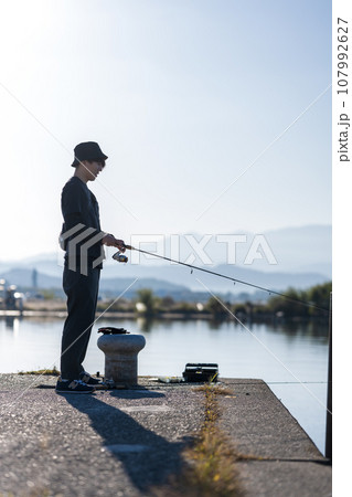 晴れた日の早朝に釣りを楽しむ若い男性 107992627