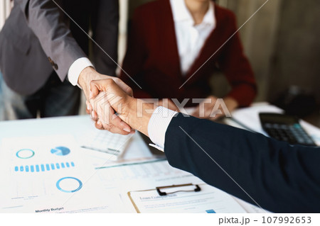 Asian entrepreneurs handshakes to congratulate the agreement between the two companies to enhance investment and financial strength. deal concept. 107992653