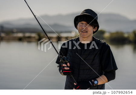 晴れた日の早朝に釣りを楽しむ若い男性 107992654