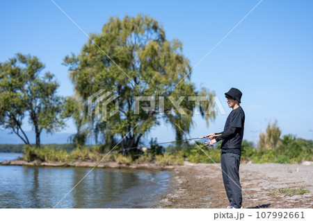 晴れた日の早朝に釣りを楽しむ若い男性 107992661