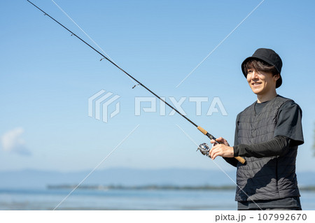 晴れた日の早朝に釣りを楽しむ若い男性 107992670