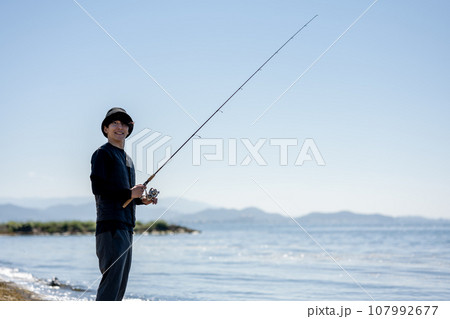 晴れた日の早朝に釣りを楽しむ若い男性 107992677