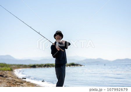 晴れた日の早朝に釣りを楽しむ若い男性 107992679
