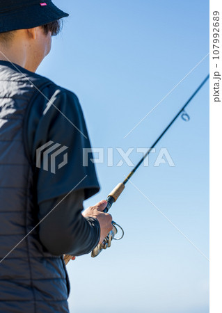 晴れた日の早朝に釣りを楽しむ若い男性 107992689