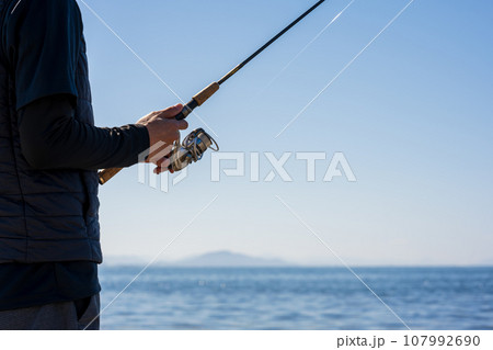 晴れた日の早朝に釣りを楽しむ若い男性 107992690