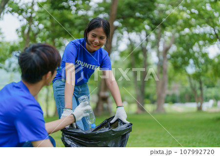 Multiethnic volunteers donate their time holding black garbage bags to collect plastic waste for recycling to reduce pollution in a public park Multiethnic volunteers donate their time holding black garbage bags to collect plastic waste for recycling to reduce pollution in a public park 107992720