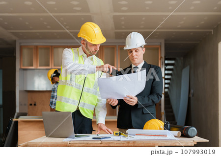 multi ethnic engineer brainstorming and measuring for cost estimating on blueprint and floor plan drawings about design architectural and engineering for houses and buildings. multi ethnic engineer brainstorming and measuring for cost estimating on blueprint and floor plan drawings about design architectural and engineering for houses and buildings. 107993019