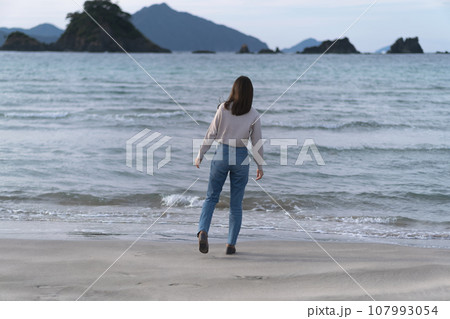 秋の海の砂浜を歩くフレアジーンズをはいた女性(福井県 若狭和田ビーチ) 秋の海の砂浜を歩くフレアジーンズをはいた女性(福井県 若狭和田ビーチ) 107993054
