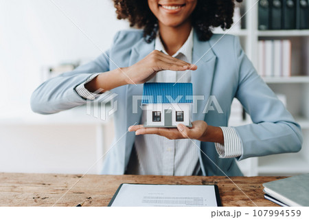 Real estate african american, Agent, buy and sell land, property tax, show the concept of protecting the house to insure the risk of damage to the home. insurance concepts. Real estate african american, Agent, buy and sell land, property tax, show the concept of protecting the house to insure the risk of damage to the home. insurance concepts. 107994559