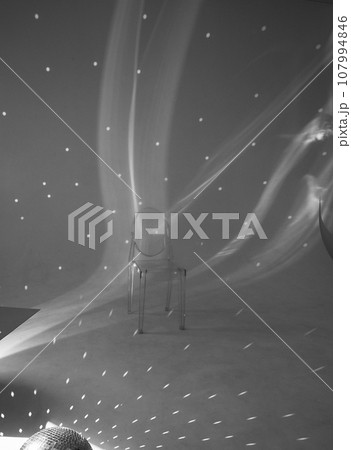 Bright room, futurism. Disco ball and glare on the wall. Transparent chair. Minimalism 107994846